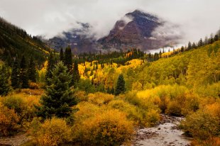 Maroon Bells concealed by autumn fog and autumn colors, near Aspen
